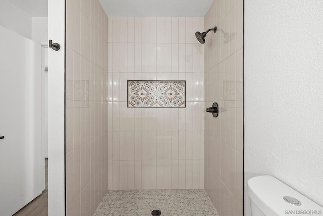 bathroom with toilet and tiled shower