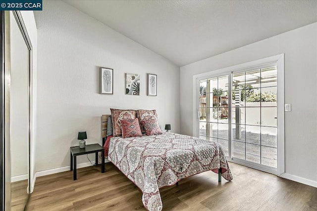 bedroom featuring hardwood / wood-style floors and vaulted ceiling