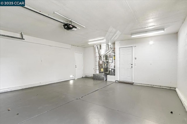 garage featuring heating unit and a garage door opener