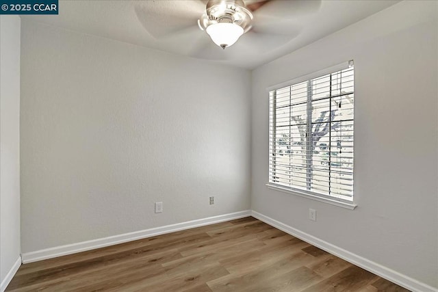 spare room with ceiling fan and wood-type flooring