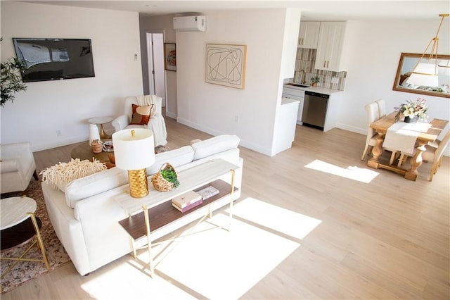 living room featuring a wall unit AC and light wood-type flooring