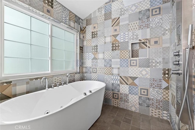 bathroom with tile patterned floors, tile walls, a tub to relax in, and plenty of natural light