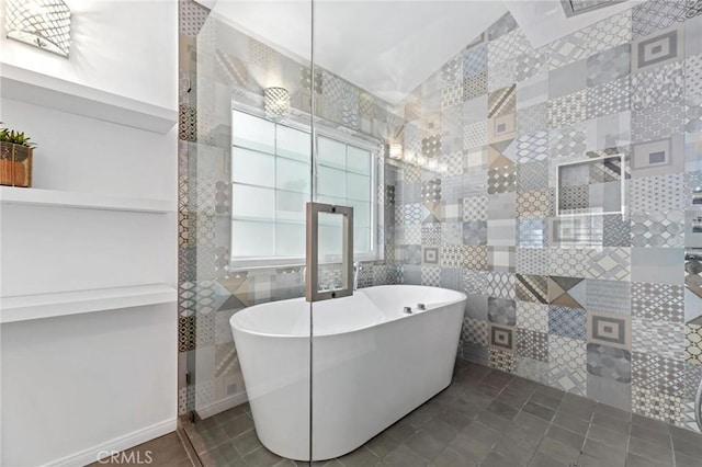 bathroom with tile patterned floors and a bath