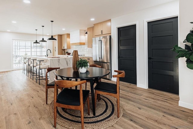 dining area featuring sink and light wood-type flooring