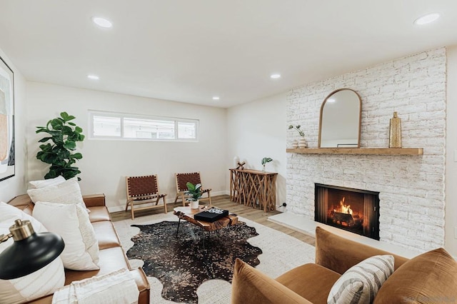 living room with light hardwood / wood-style flooring and a stone fireplace