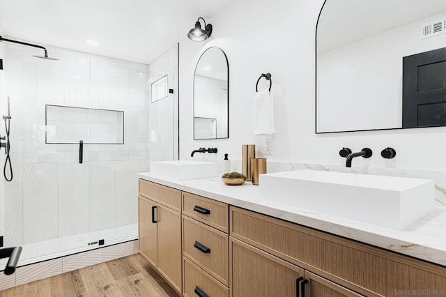 bathroom with vanity, a shower with door, and hardwood / wood-style floors