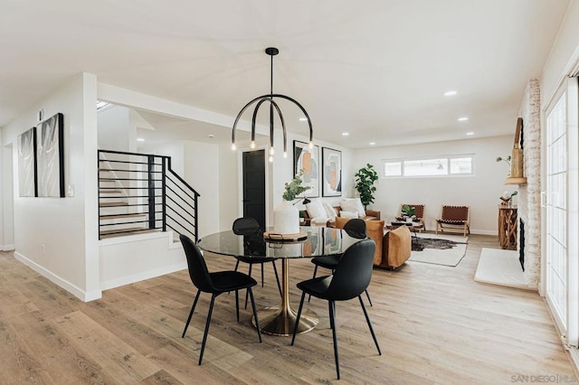 dining space with a notable chandelier and light hardwood / wood-style flooring