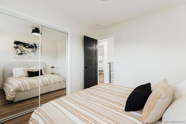 bedroom with dark wood-type flooring and a closet