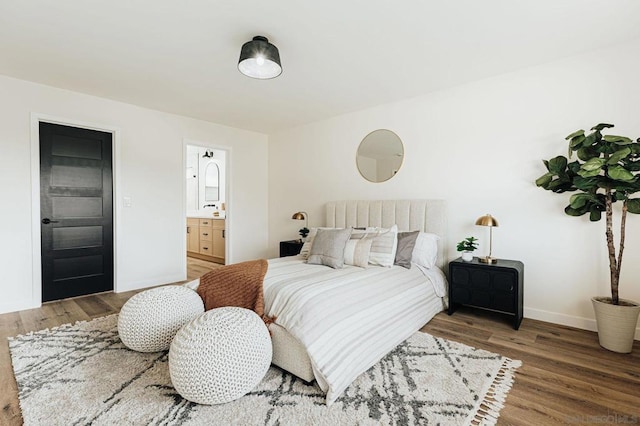 bedroom featuring sink, hardwood / wood-style floors, and ensuite bathroom