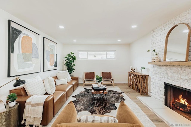 living room featuring light wood-type flooring and a fireplace