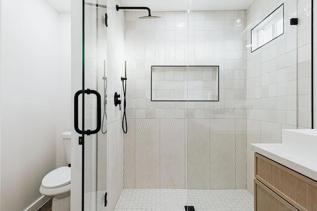 bathroom with toilet, vanity, and an enclosed shower