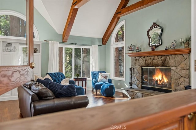 living room with hardwood / wood-style flooring, vaulted ceiling with beams, and a fireplace