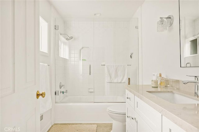 full bathroom featuring toilet, enclosed tub / shower combo, and vanity