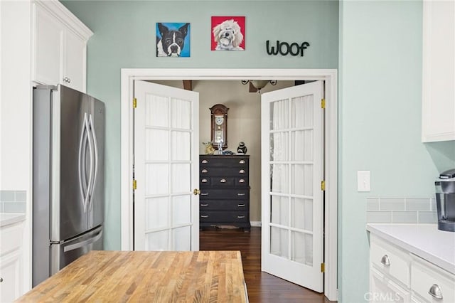 kitchen featuring french doors, dark hardwood / wood-style flooring, white cabinets, and stainless steel refrigerator