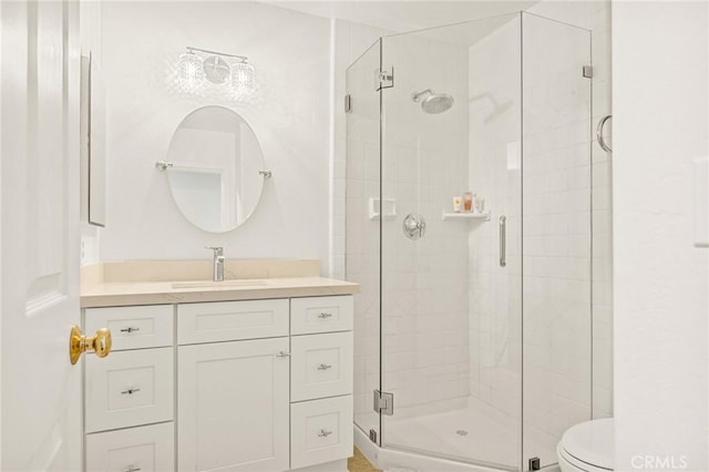 bathroom with toilet, a shower with shower door, and vanity