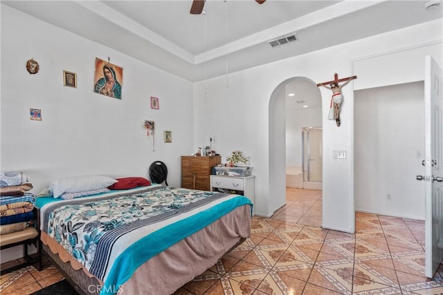 tiled bedroom featuring ensuite bathroom and ceiling fan