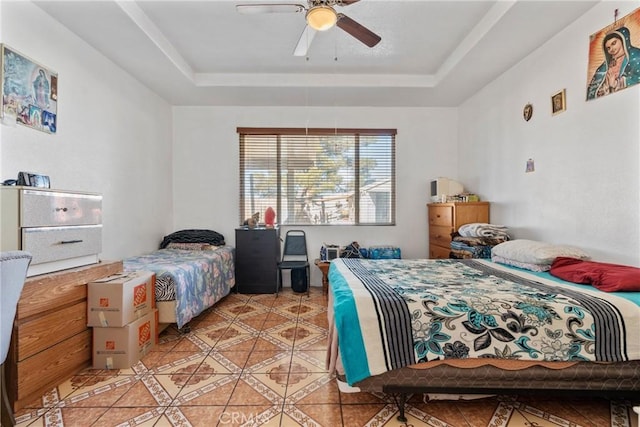 bedroom featuring light tile patterned flooring, ceiling fan, and a tray ceiling