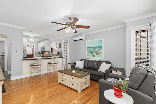 living room with ceiling fan, light hardwood / wood-style floors, ornamental molding, and a wall unit AC