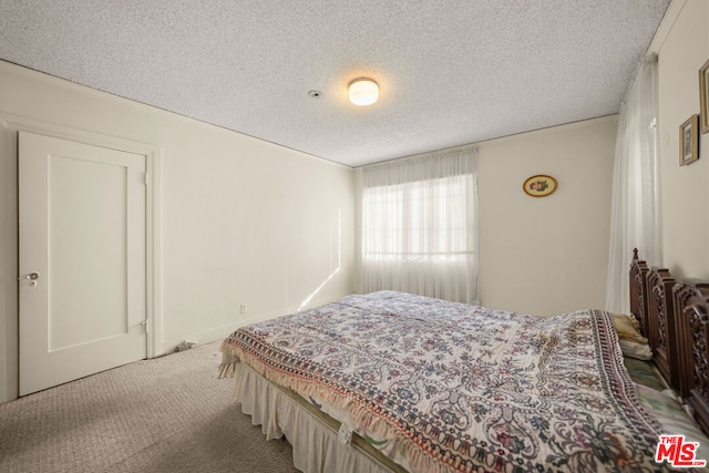 bedroom with a textured ceiling and carpet flooring