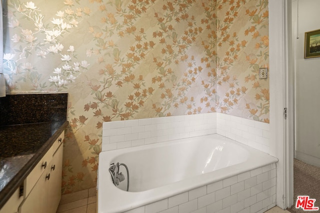 bathroom featuring vanity and a relaxing tiled tub