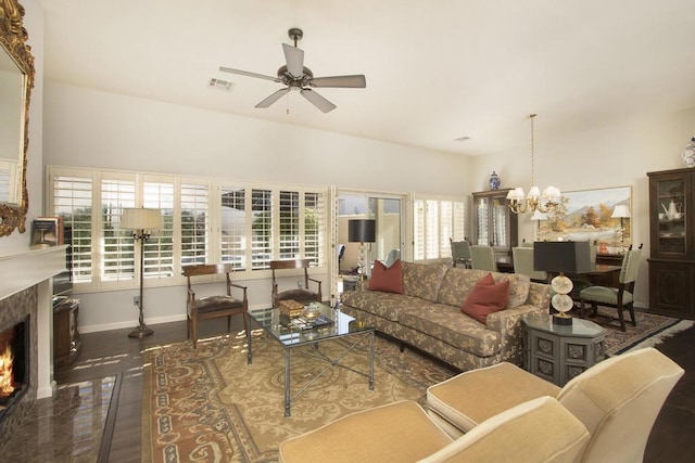 living room with ceiling fan with notable chandelier, dark hardwood / wood-style floors, and a premium fireplace