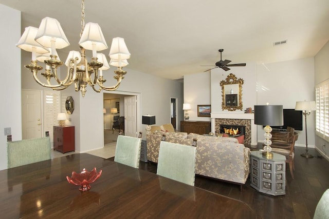 dining area with lofted ceiling, ceiling fan with notable chandelier, and dark wood-type flooring