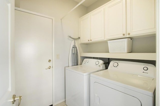 clothes washing area featuring cabinets and washing machine and dryer