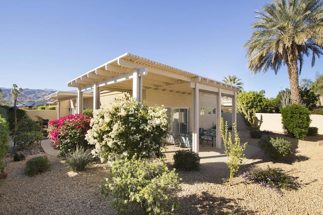 rear view of property with a patio, a mountain view, and a pergola