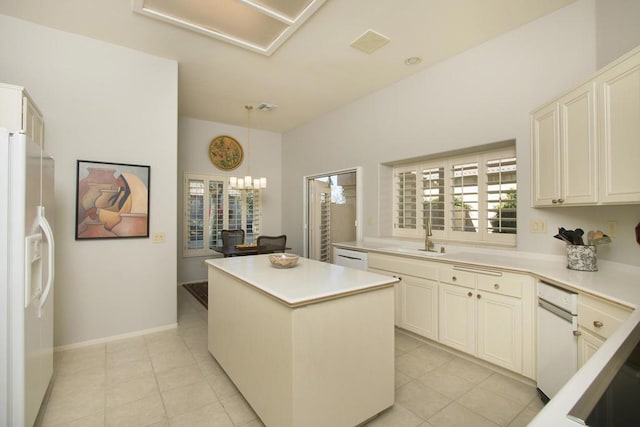 kitchen with sink, a kitchen island, a notable chandelier, pendant lighting, and white appliances