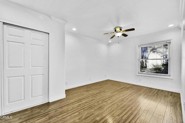 spare room with ceiling fan, ornamental molding, and wood-type flooring