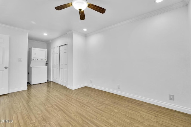 unfurnished bedroom with stacked washer and clothes dryer, light hardwood / wood-style floors, ceiling fan, a closet, and ornamental molding