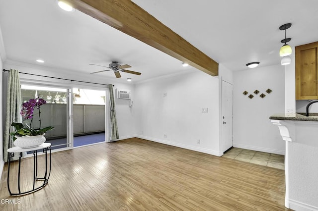 unfurnished living room with beam ceiling, light wood-type flooring, and ceiling fan