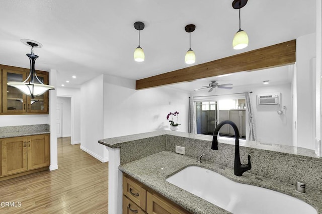 kitchen with ceiling fan, decorative light fixtures, sink, beamed ceiling, and light stone countertops