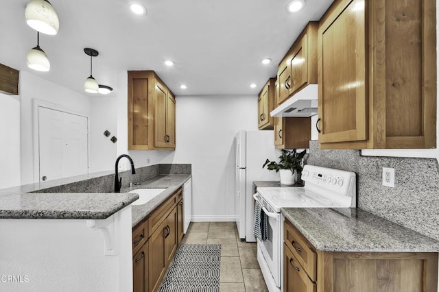 kitchen featuring white appliances, decorative light fixtures, sink, kitchen peninsula, and stone counters