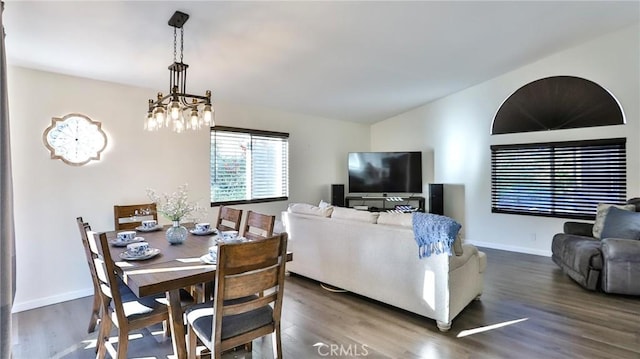 dining space with an inviting chandelier and dark hardwood / wood-style floors