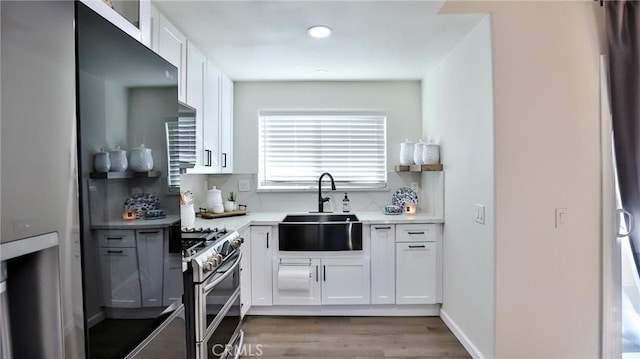 kitchen featuring sink, white cabinetry, backsplash, and stainless steel appliances