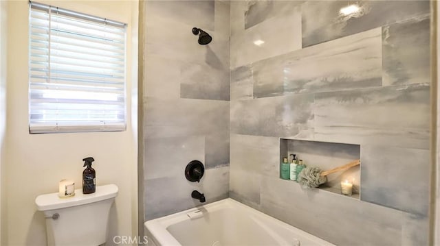 bathroom featuring toilet and tiled shower / bath