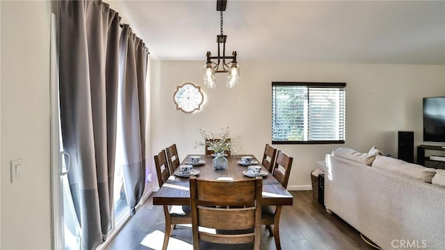 dining room with dark hardwood / wood-style floors and an inviting chandelier