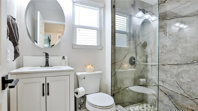 bathroom with toilet, a tile shower, and vanity