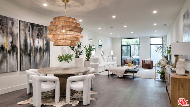 dining space featuring dark hardwood / wood-style floors, a chandelier, and a wall of windows