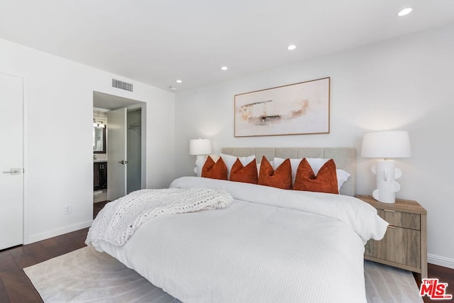 bedroom featuring dark hardwood / wood-style floors and ensuite bathroom