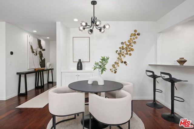 dining area featuring dark hardwood / wood-style floors and an inviting chandelier