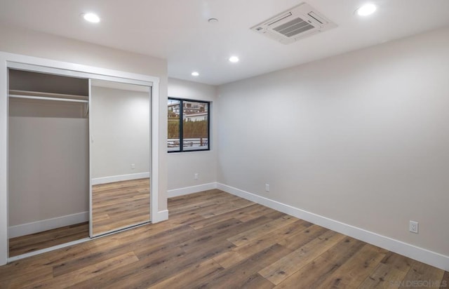 unfurnished bedroom featuring hardwood / wood-style floors and a closet