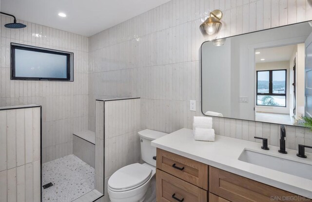 bathroom with toilet, tile walls, and tiled shower