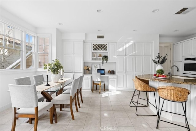 dining space featuring sink and light tile patterned floors