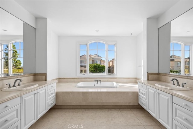 bathroom featuring tile patterned floors, vanity, a wealth of natural light, and a tub