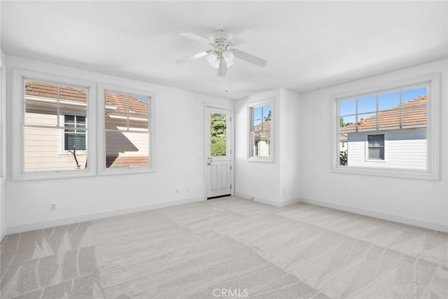 carpeted spare room featuring ceiling fan