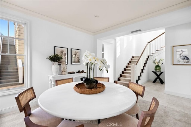 tiled dining space featuring ornamental molding