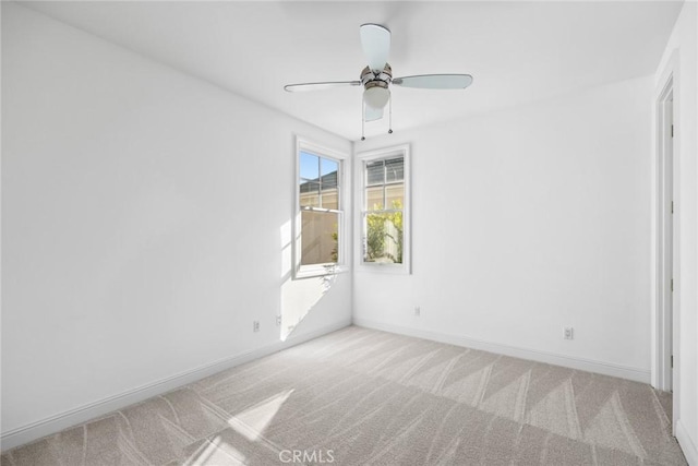 carpeted spare room with ceiling fan