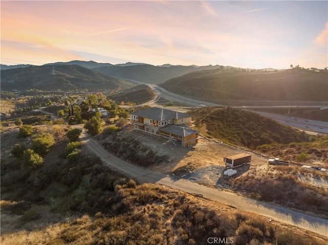 aerial view at dusk featuring a mountain view